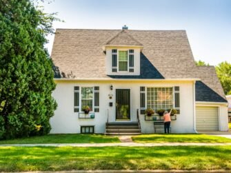 man-in-black-shirt-sitting-on-chair-near-white-wooden-house-during-daytime-w8z6aiwfi1e