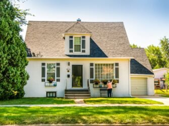 man-in-black-shirt-sitting-on-chair-near-white-wooden-house-during-daytime-w8z6aiwfi1e